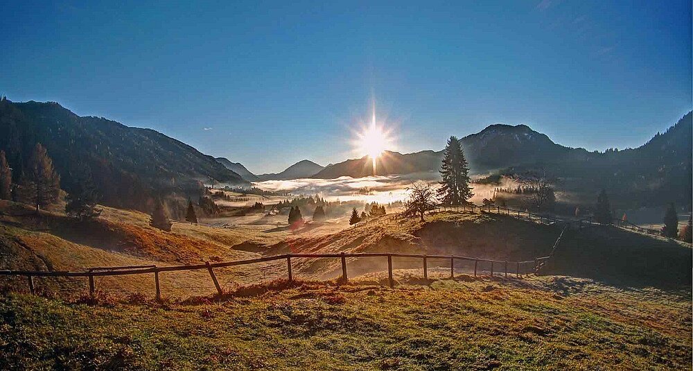 Sommerlicher Sonnenuntergang über dem Weissensee mit Spiegelung im Wasser Sommerlicher Sonnenuntergang über dem Weissensee mit Spiegelung im Wasser