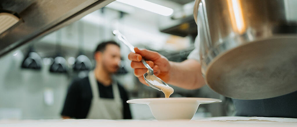 Mitglied der Gastgeberfamilie bei der Arbeit in der Seelen.Küche Hotel zum Weissensee